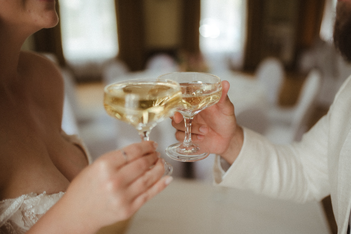 Brautpaar stößt am Hochzeitstag mit Champagner an – natürliche, emotionale Hochzeitsfotografie