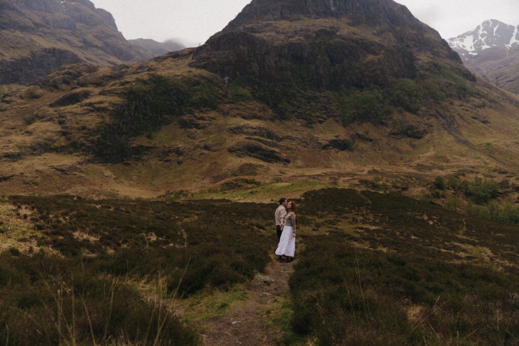 Paar inmitten einer wilden Berglandschaft in den schottischen Highlands – emotionale Elopement Fotografie