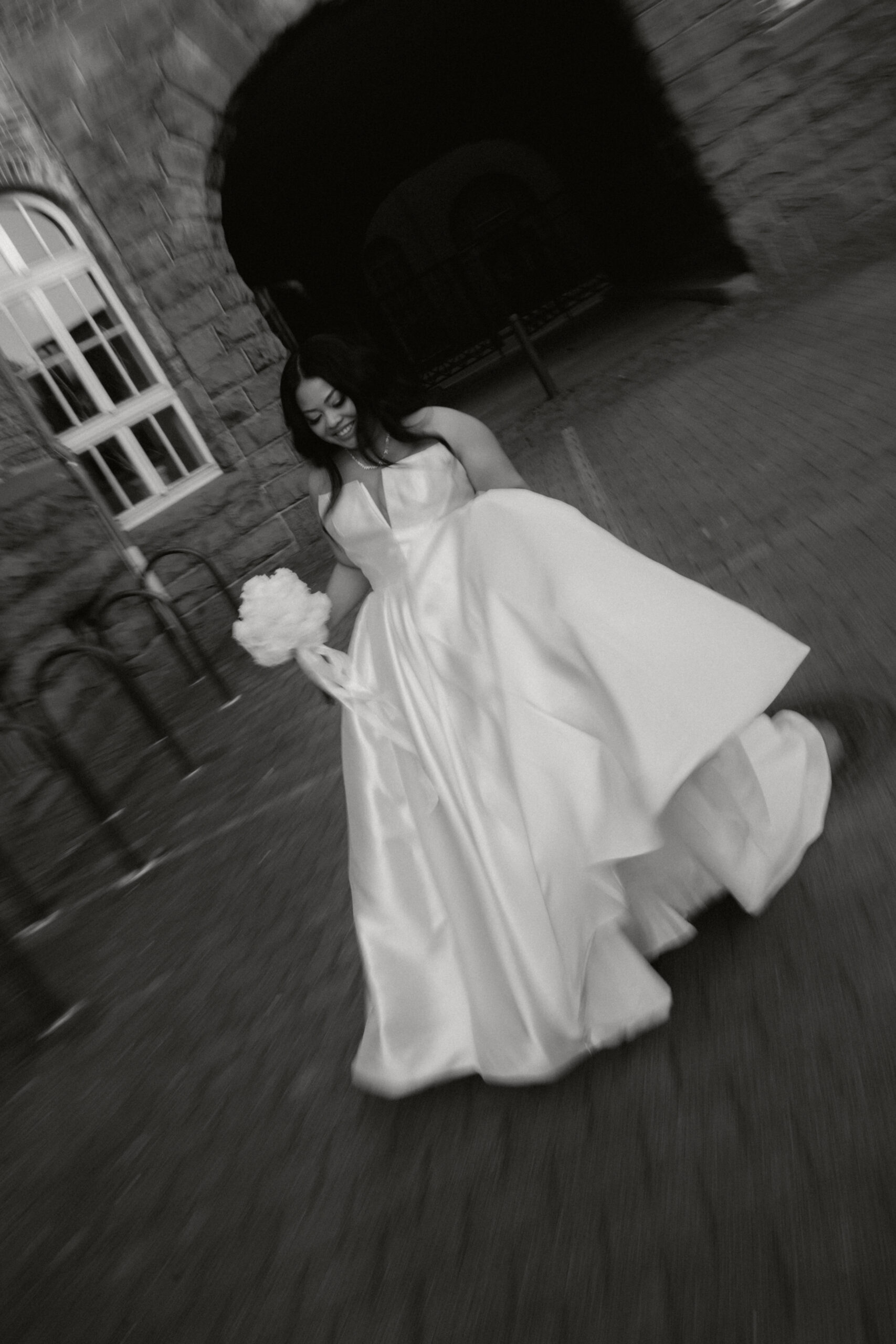 Braut mit Brautstrauß in Bewegung – cinematische Hochzeitsfotografie in Schwarz-Weiß